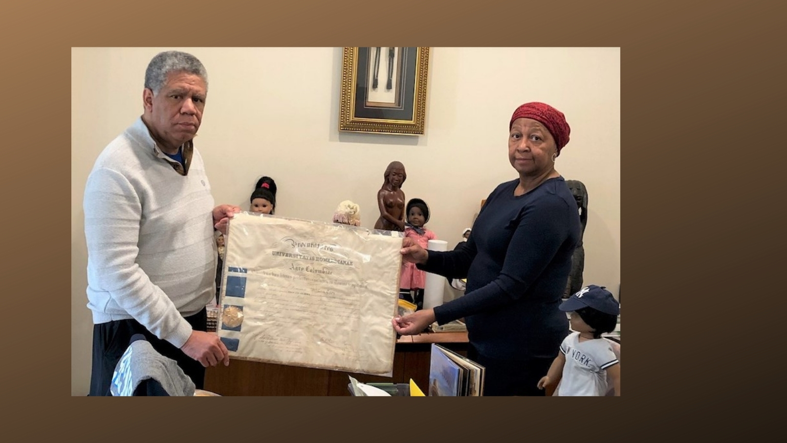 Melva and DeWitte Shipley with college diploma of family member William Troy and other items from Maris Grove's Black History Month exhibit.