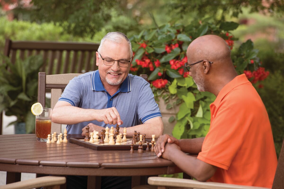 Two men play chess outdoors