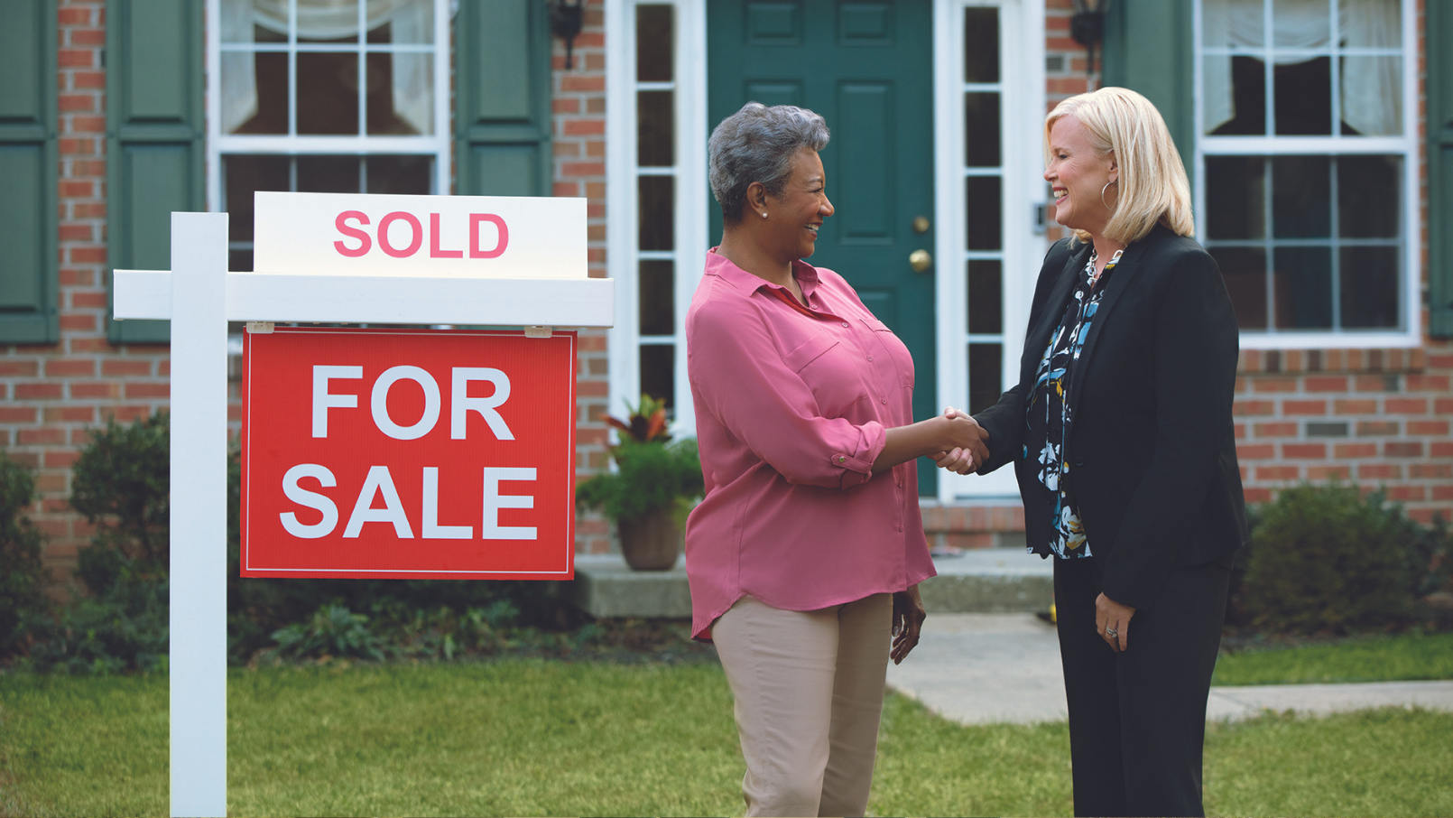 Seller and real estate agent shaking hands Sold home