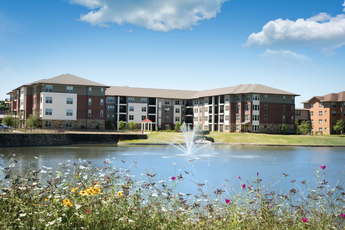 ETH_5_2017_exterior_1200x800 One of the buildings at Eagle's Trace senior living community is pictured across a scenic pond with fountain