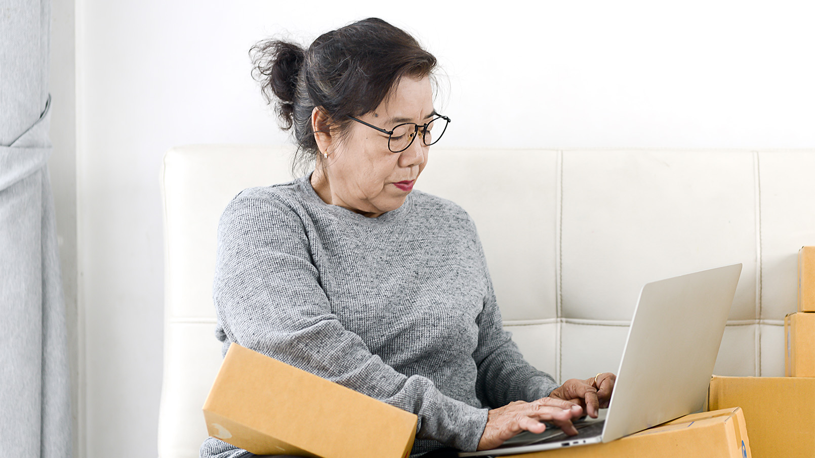 Getty-1172627977_1610x906 woman with boxes and a laptop