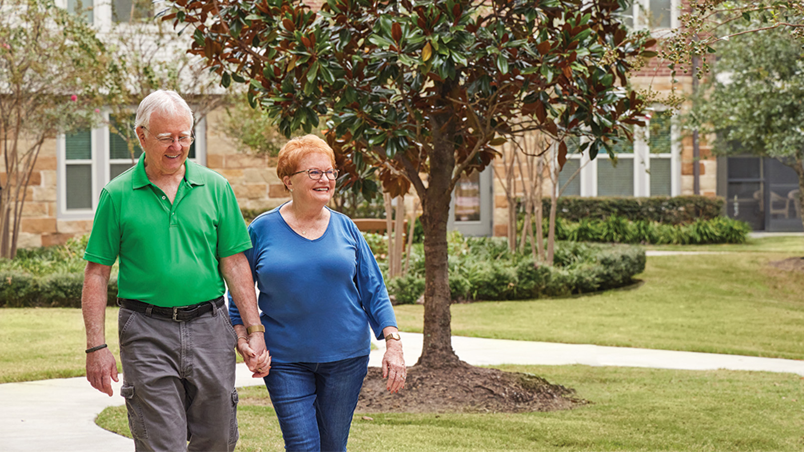 A happy couple walks the beautifully landscaped grounds of Eagle's Trace in West Houston.