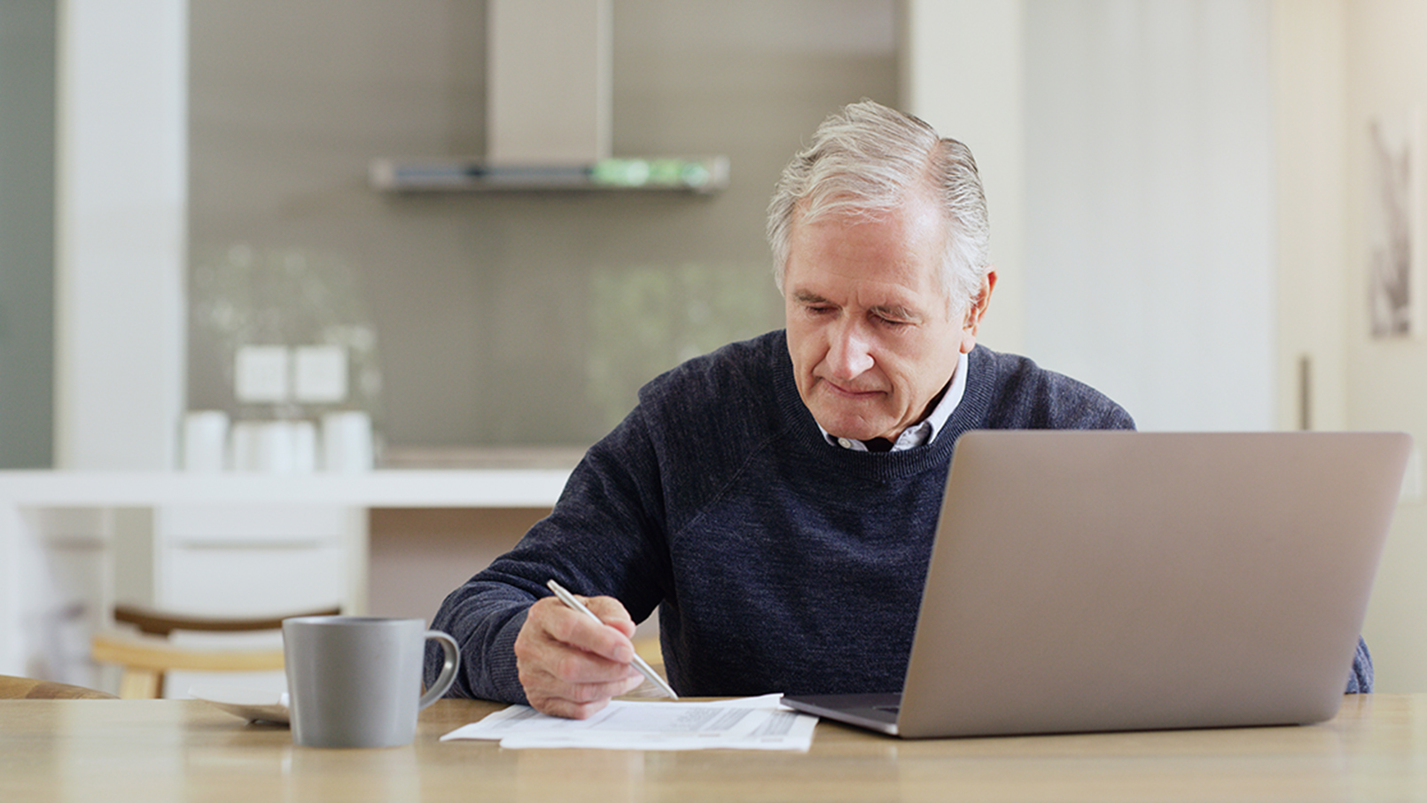man reviewing documents at laptop