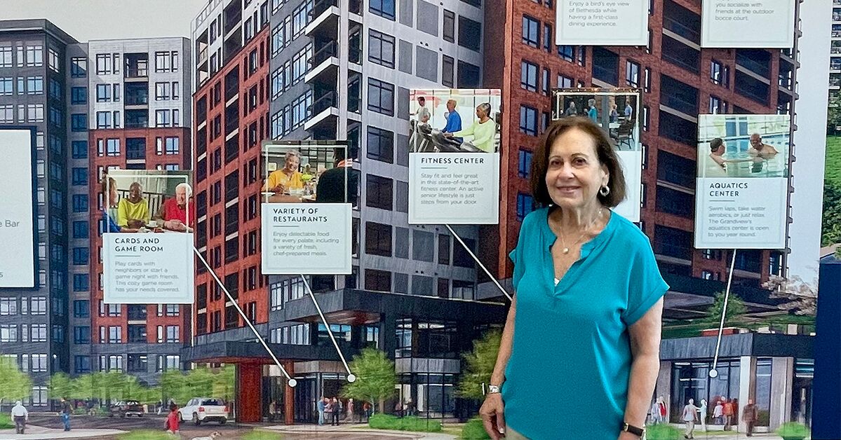 Marsha Greenfield stands in front of a display in the Sales Center for The Grandview.