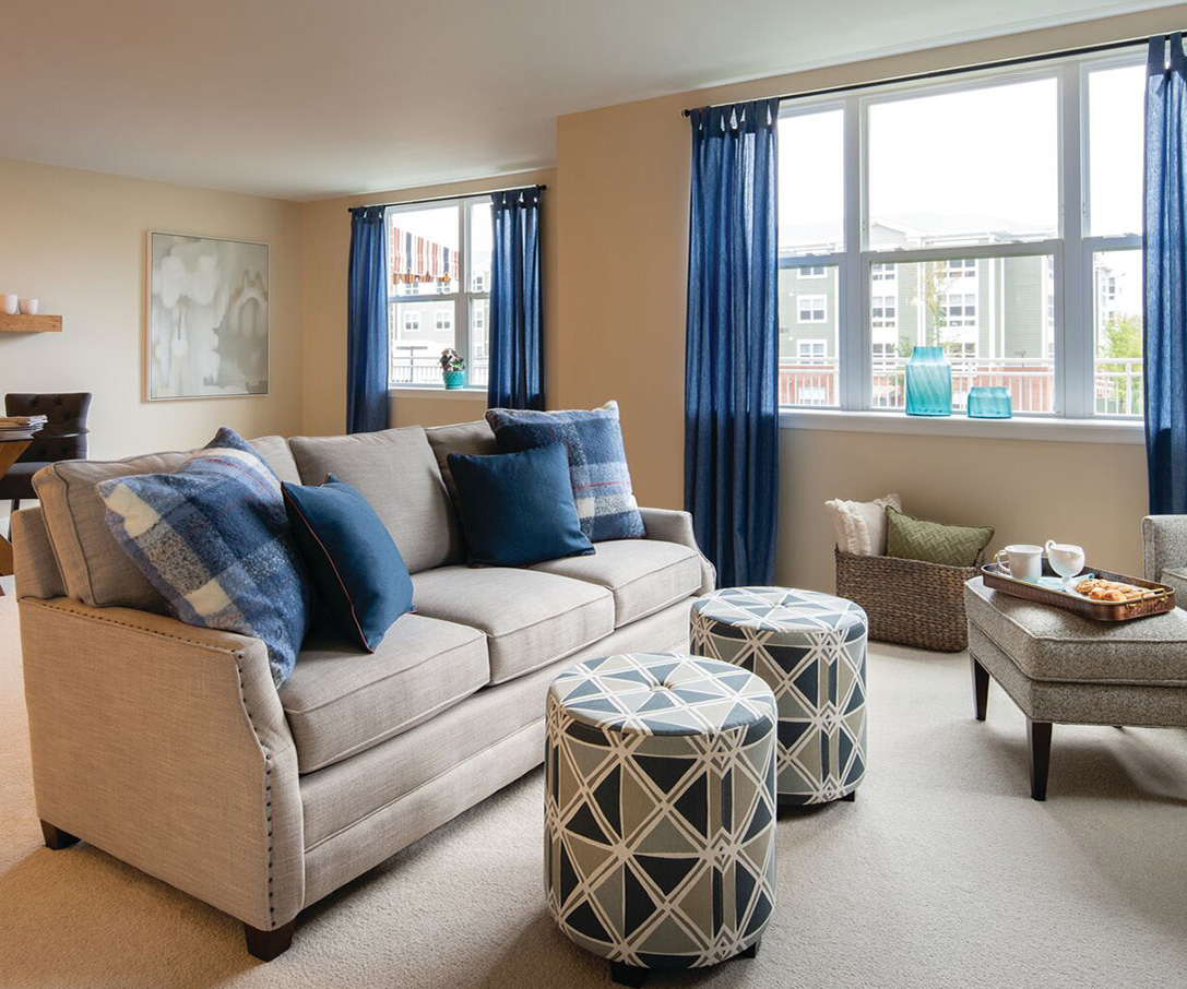 Spacious, open living room decorated with modern furniture in an Erickson apartment home.