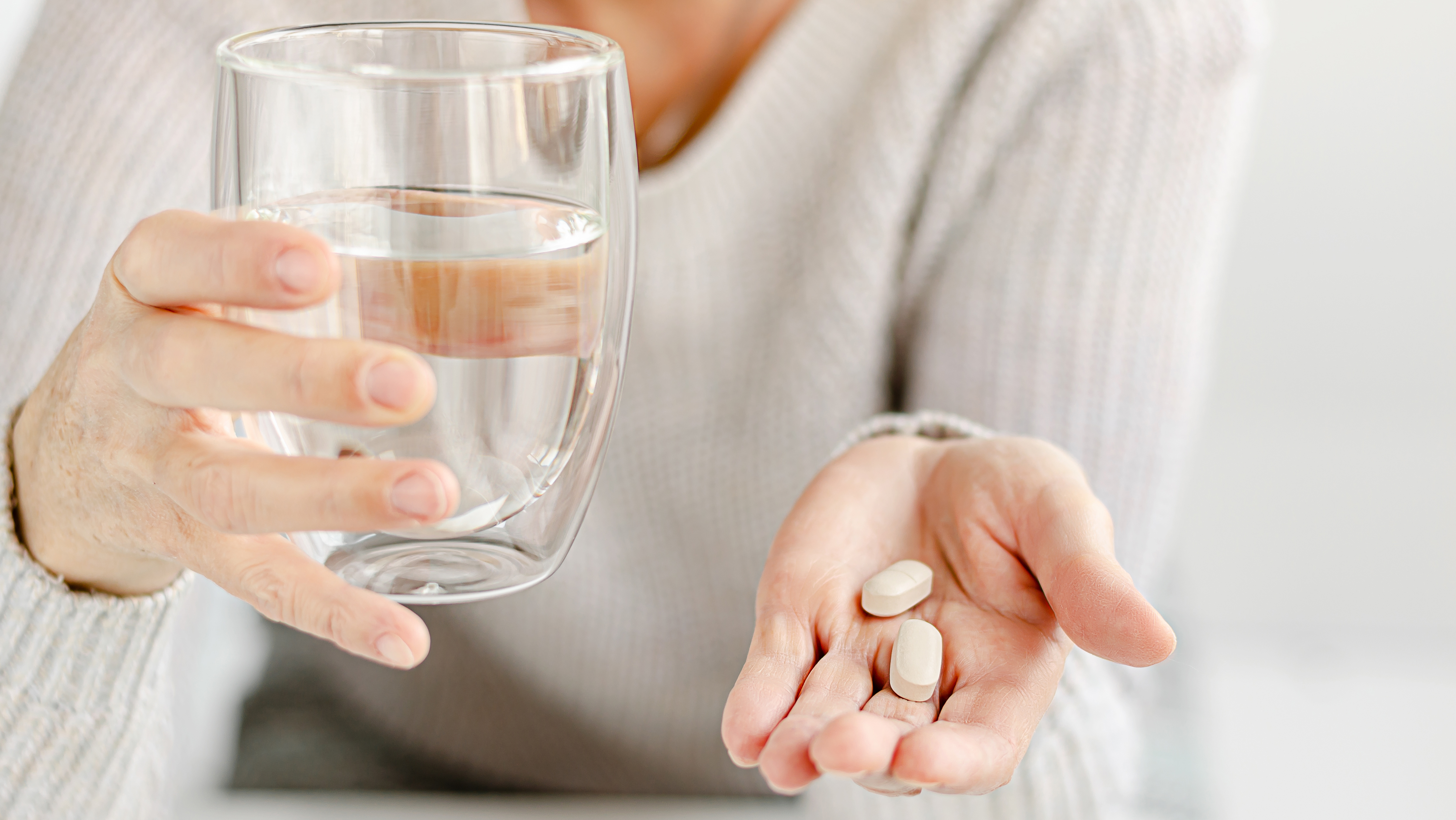 woman holding multivitamin in hand