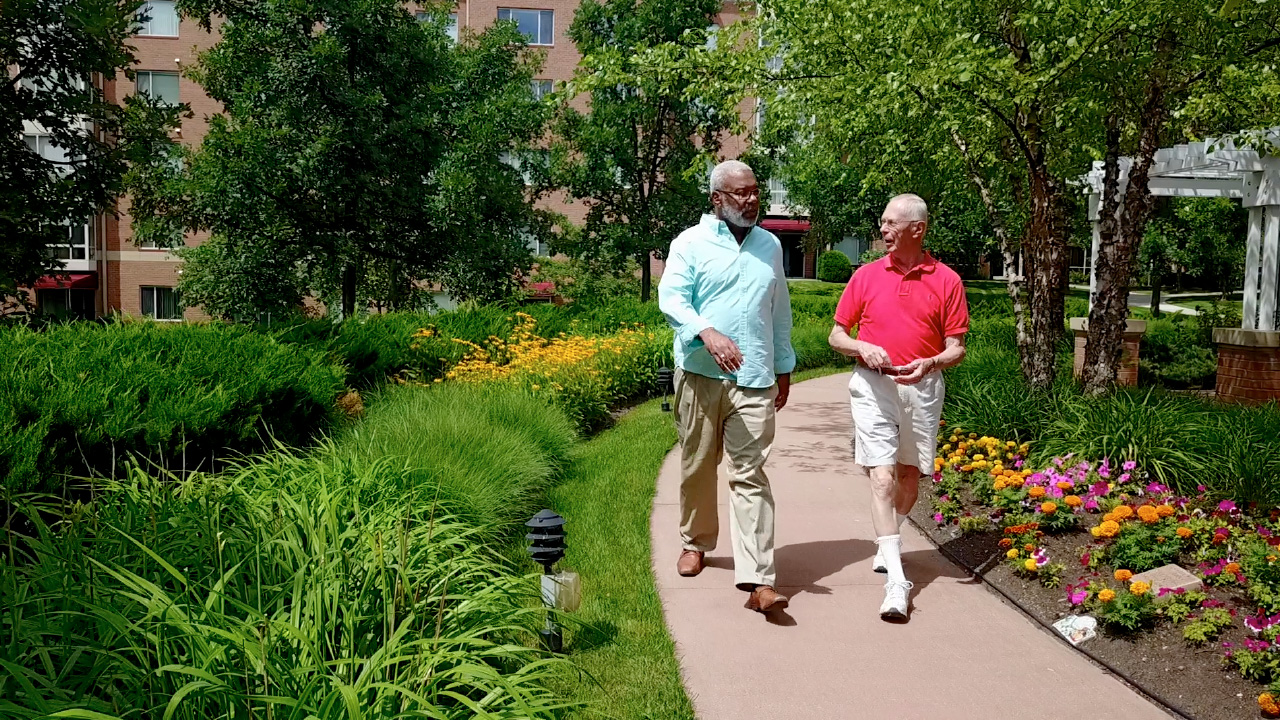 Two residents enjoying and outdoor walking path.