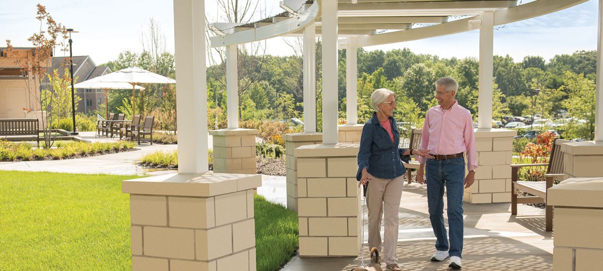 Erickson residents enjoy a walk outside under a covered pathway.