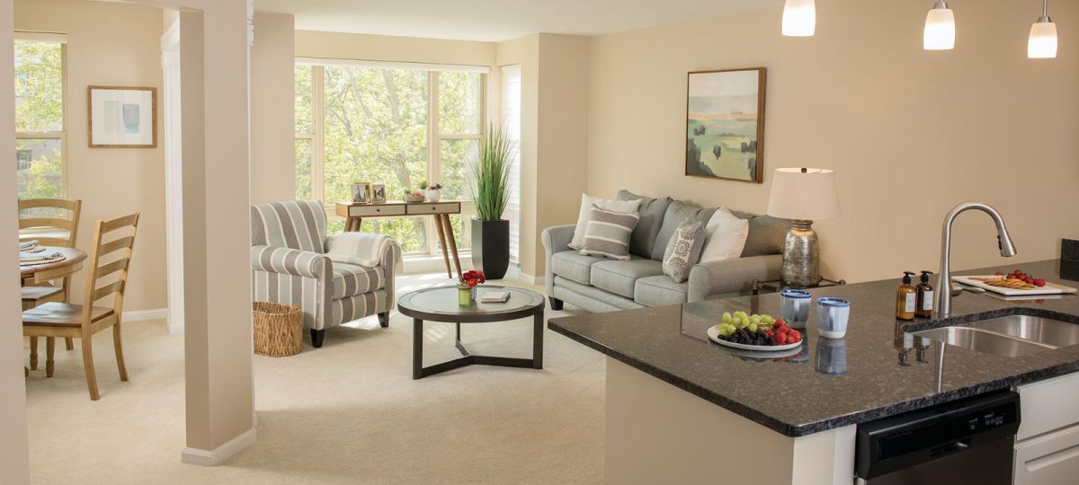 Open concept kitchen and living room with large windows.