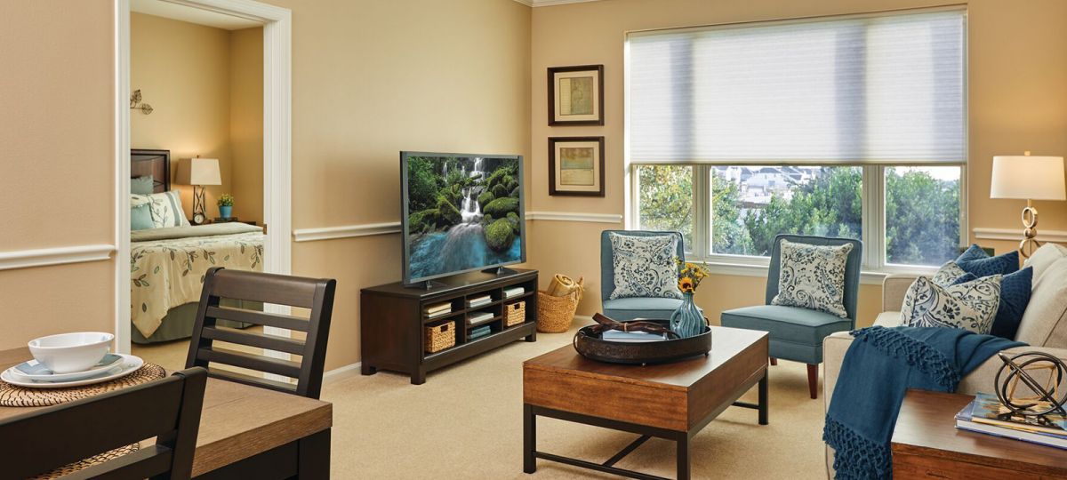 Living room with large window, TV and coffee table.