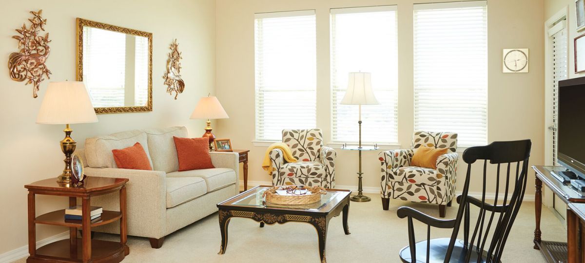 Big living room with several seating areas and large windows.