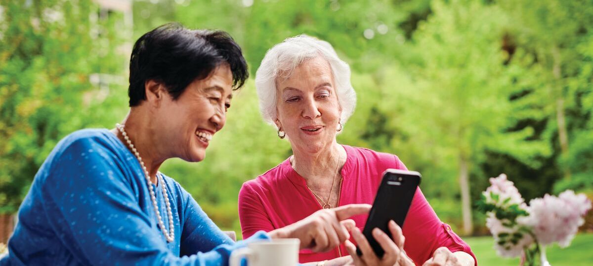 tech savvy Two women look at a smart phone