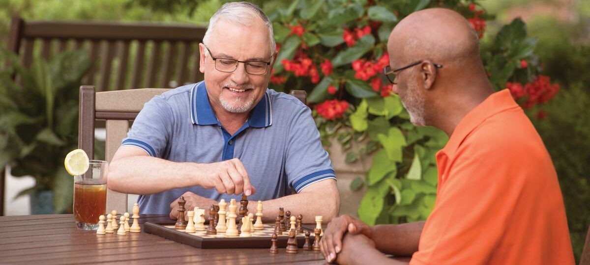 Two men play chess outdoors