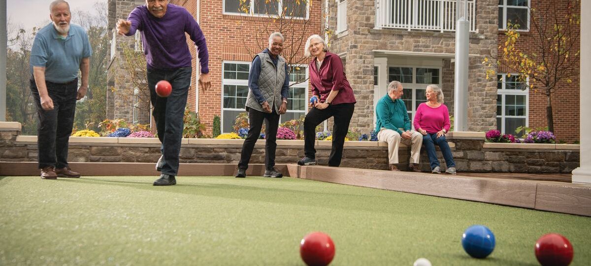 Image of Erickson residents playing Bocce on the community lawn.