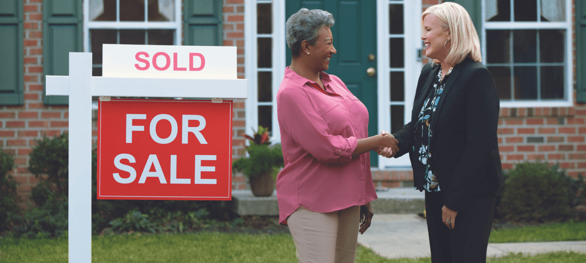 Seller and real estate agent shaking hands Sold home