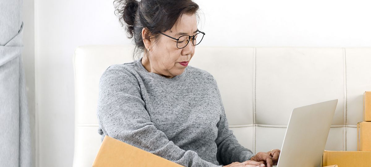 Getty-1172627977_1610x906 woman with boxes and a laptop