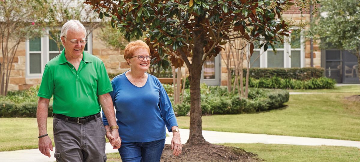 A happy couple walks the beautifully landscaped grounds of Eagle's Trace in West Houston.