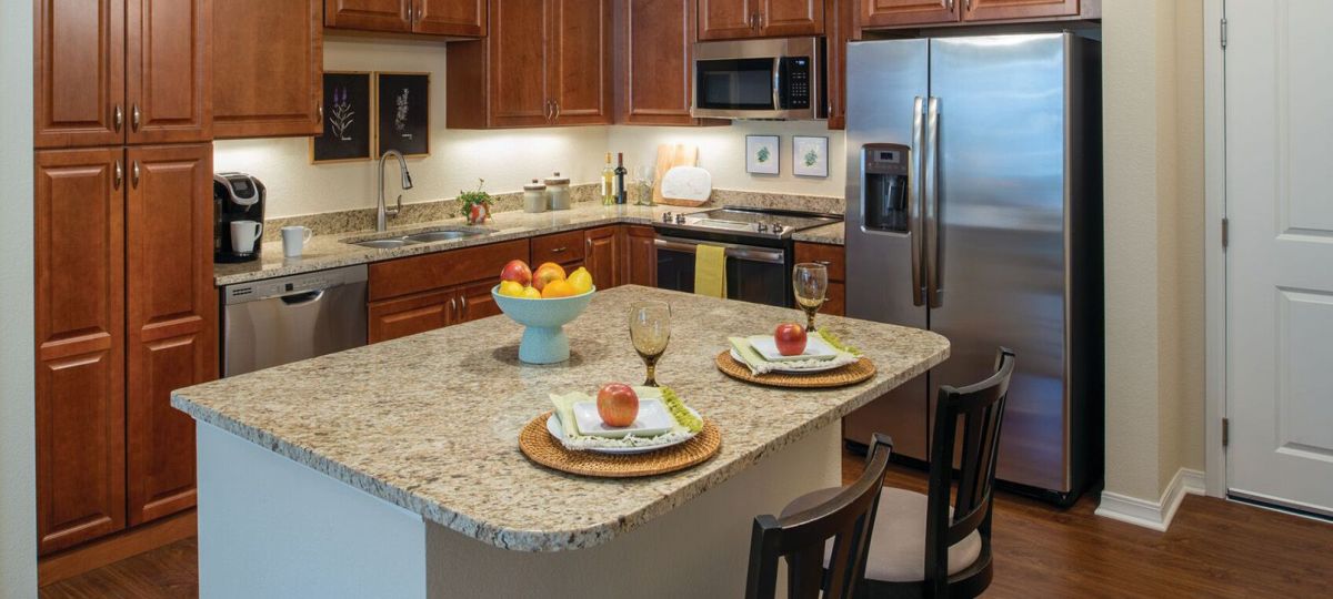 Interior shot of kitchen with stainless steel appliances inside of an Erickson two-bedroom apartment home.