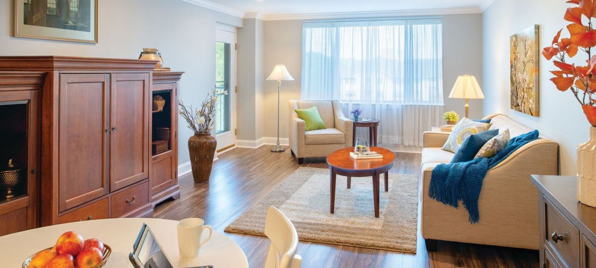 Wide shot of the spacious, bright, furnished living and dining rooms.