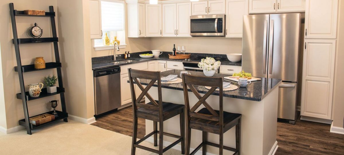 Interior shot of a kitchen with stainless steel appliances and breakfast bar in an Erickson two-bedroom apartment.