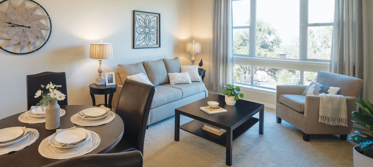 Wide shot of dining room and spacious, open living room.