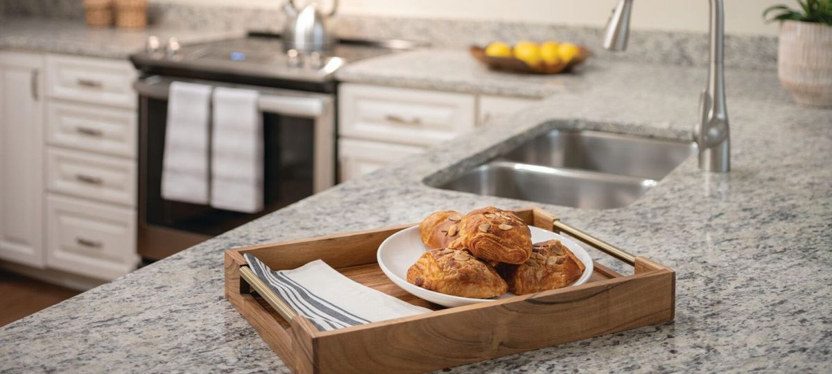 Close-up shot of a tray of pastries setting on top of a granite counter in the kitchen.