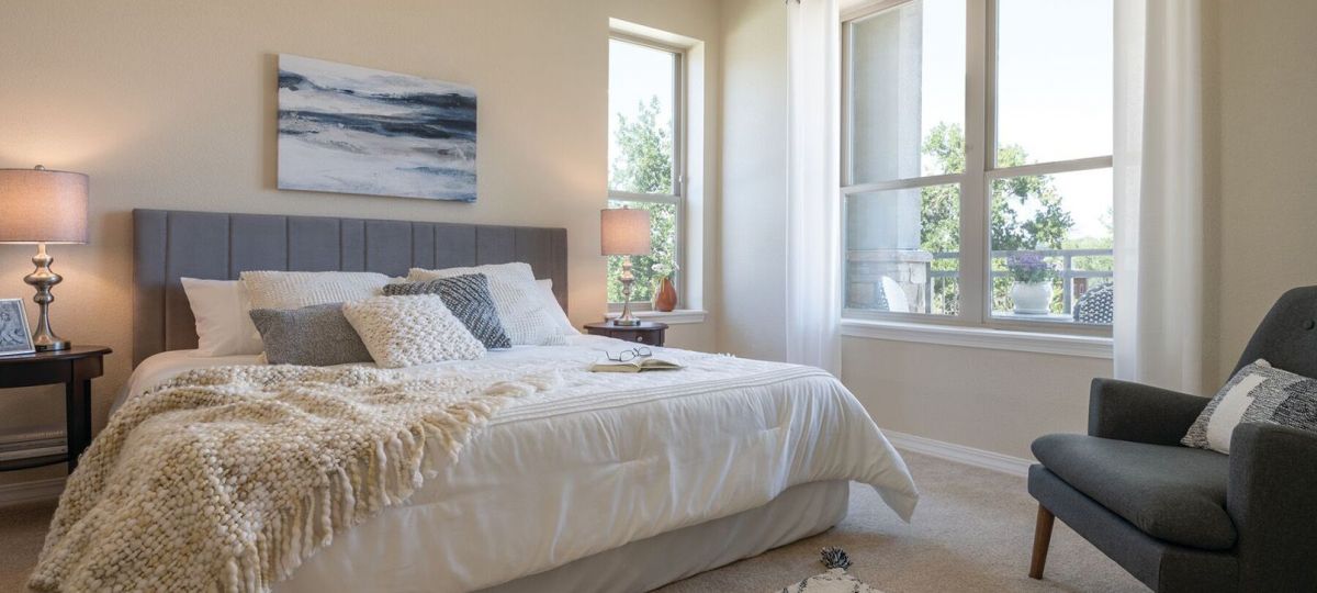 Wide shot of the bright, furnished main bedroom.