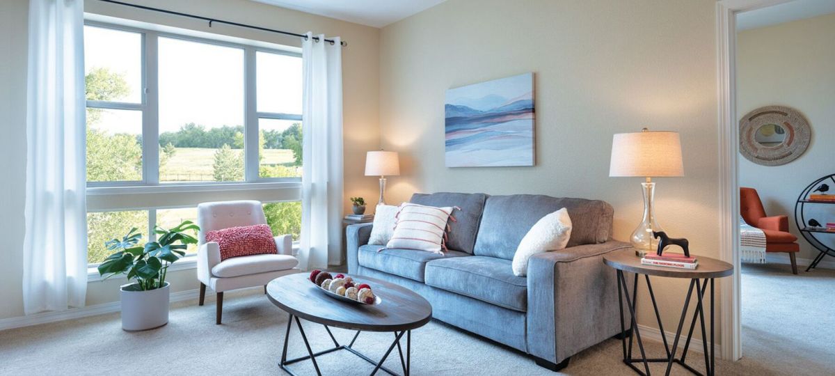 Interior shot of a nicely decorated, open living room in an Erickson two-bedroom apartment home.