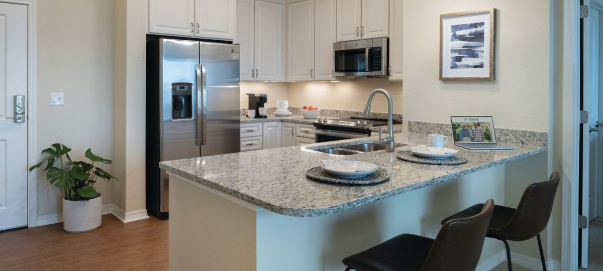 Interior shot of kitchen and breakfast bar inside of an Erickson two-bedroom apartment home.