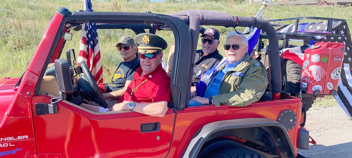 Wind Crest residents in a patriotic Jeep