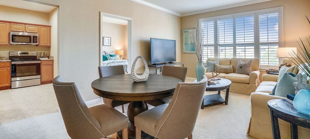 Wide shot of dining room and spacious, open living room.