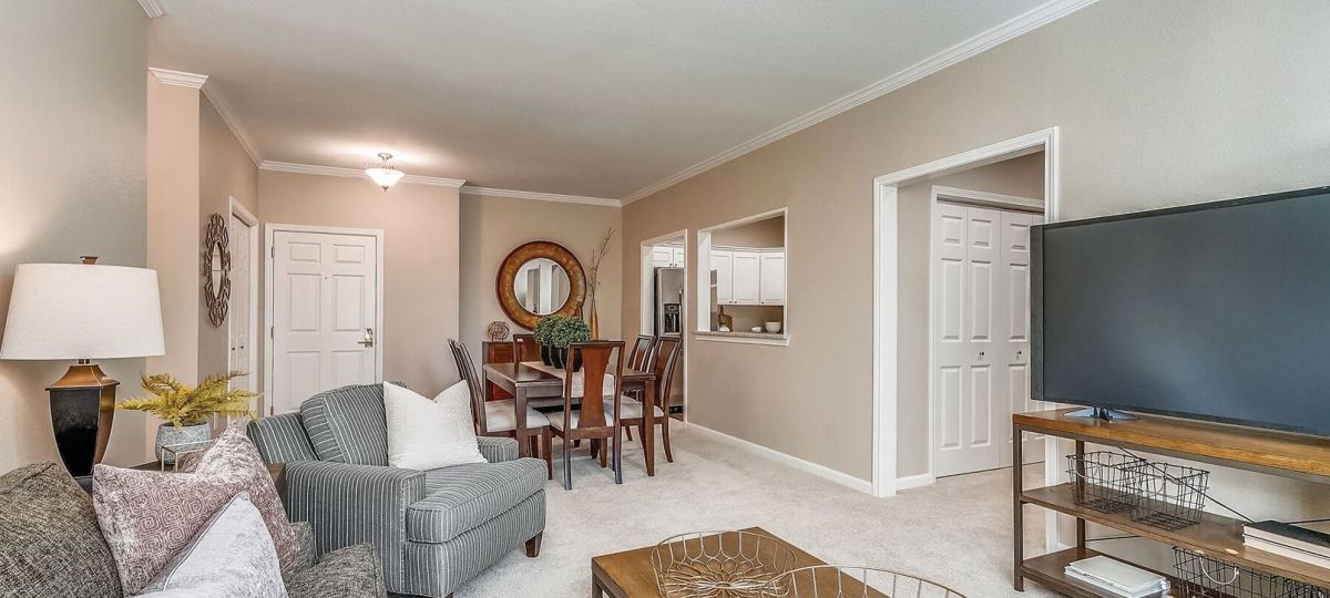 Spacious living room decorated with modern furniture and flat-screen television in an Erickson apartment.