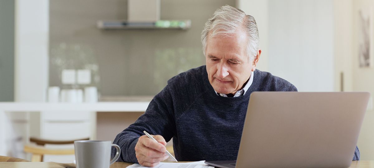 man reviewing documents at laptop
