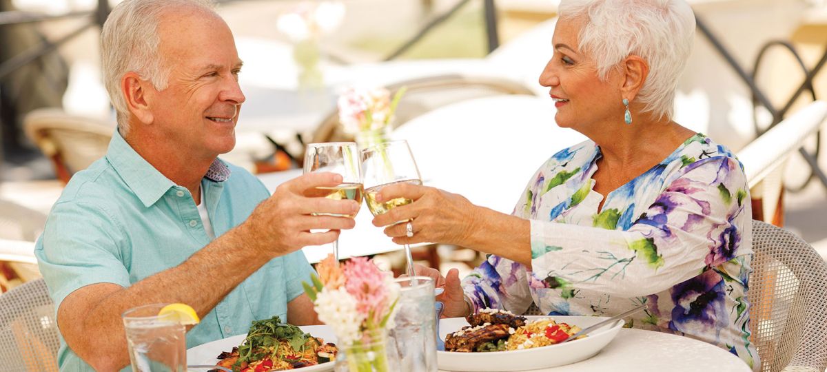 Couple enjoying a meal at an outdoor table.