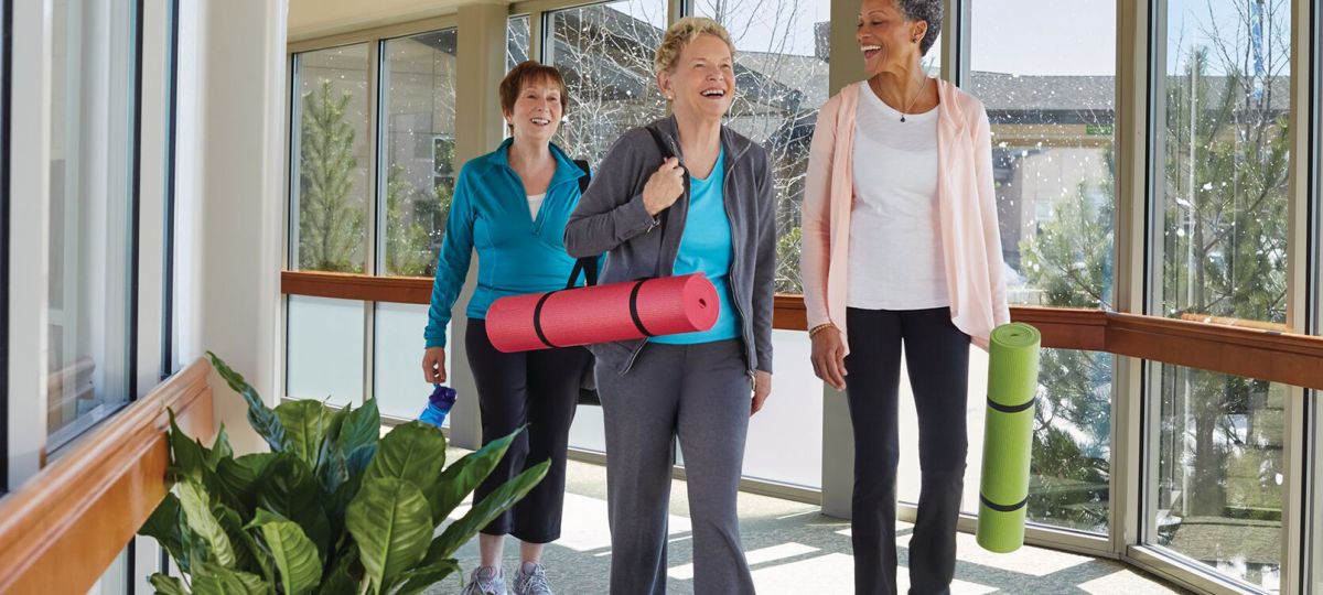 residents walking to yoga class with yoga mats