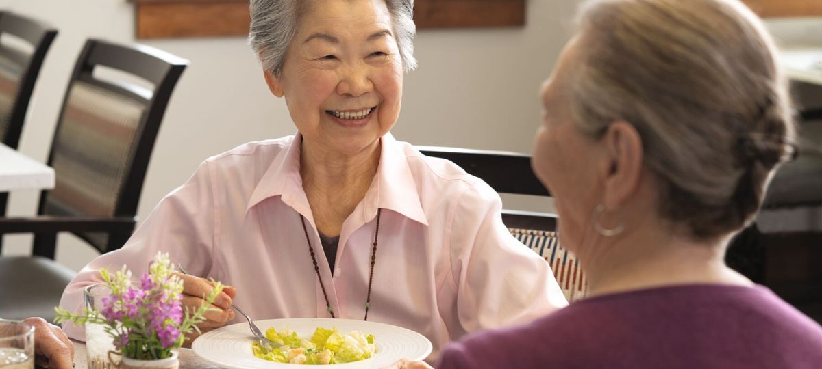 Two women enjoying a meal together at our senior living community's dining area.