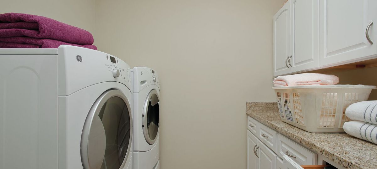 Personal apartment laundry room equipped with large, modern washing and drying machines.