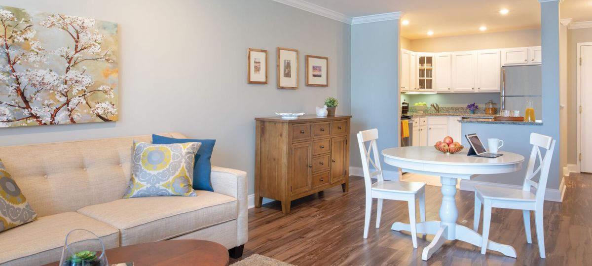 Wide angle shot of a spacious, open living room and dining area in an Erickson apartment.