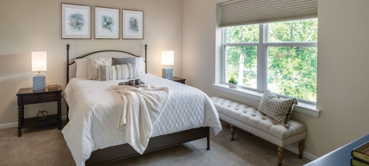Cozy bedroom in an Erickson Senior Living community apartment with modern furnishings.