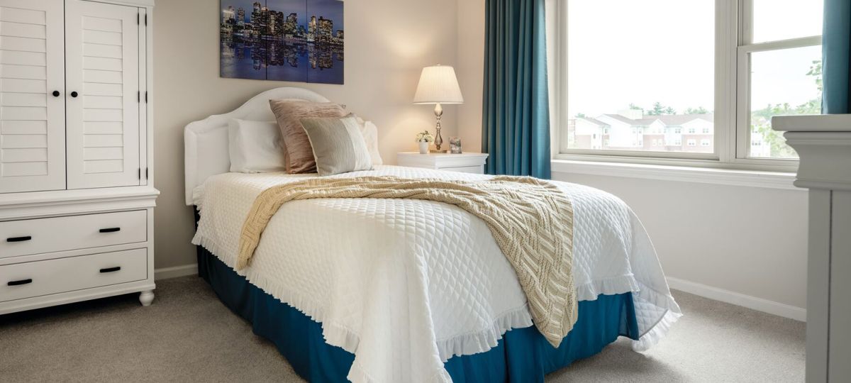 Cozy bedroom in an Erickson Senior Living community apartment with modern furnishings.