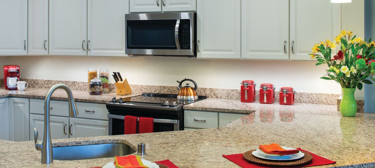 Modern kitchen in an Erickson Senior Living community apartment with updated appliances and counter seating.