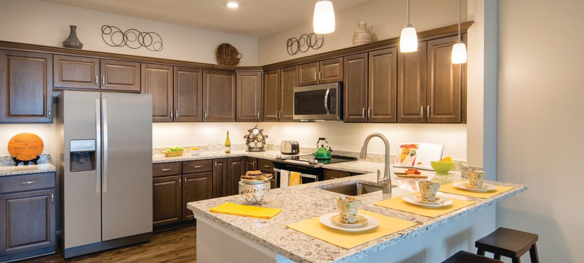 Modern kitchen in an Erickson Senior Living community apartment with updated appliances and counter seating.