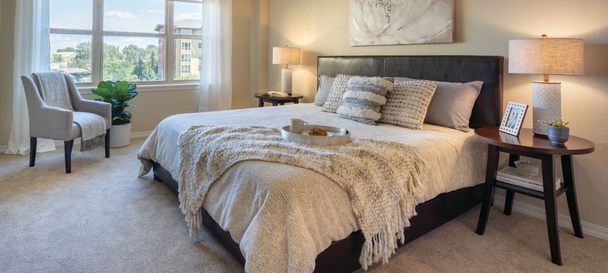 Cozy bedroom in an Erickson Senior Living community apartment with modern furnishings.