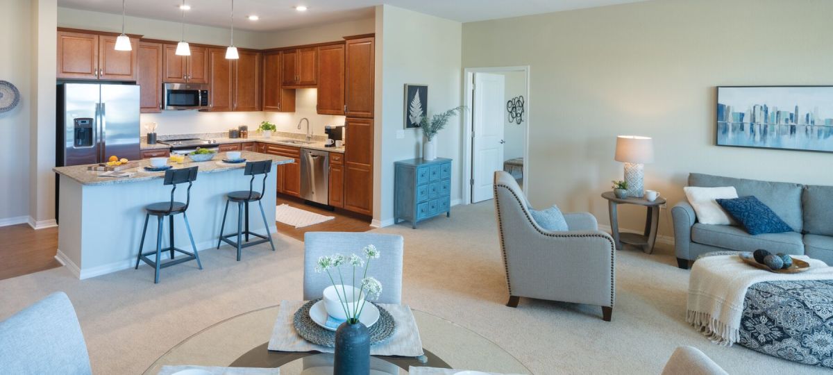 Wide angle shot of a spacious, open living room and dining area in an Erickson apartment.