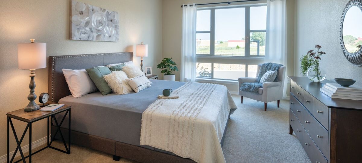 Cozy bedroom in an Erickson Senior Living community apartment with modern furnishings.