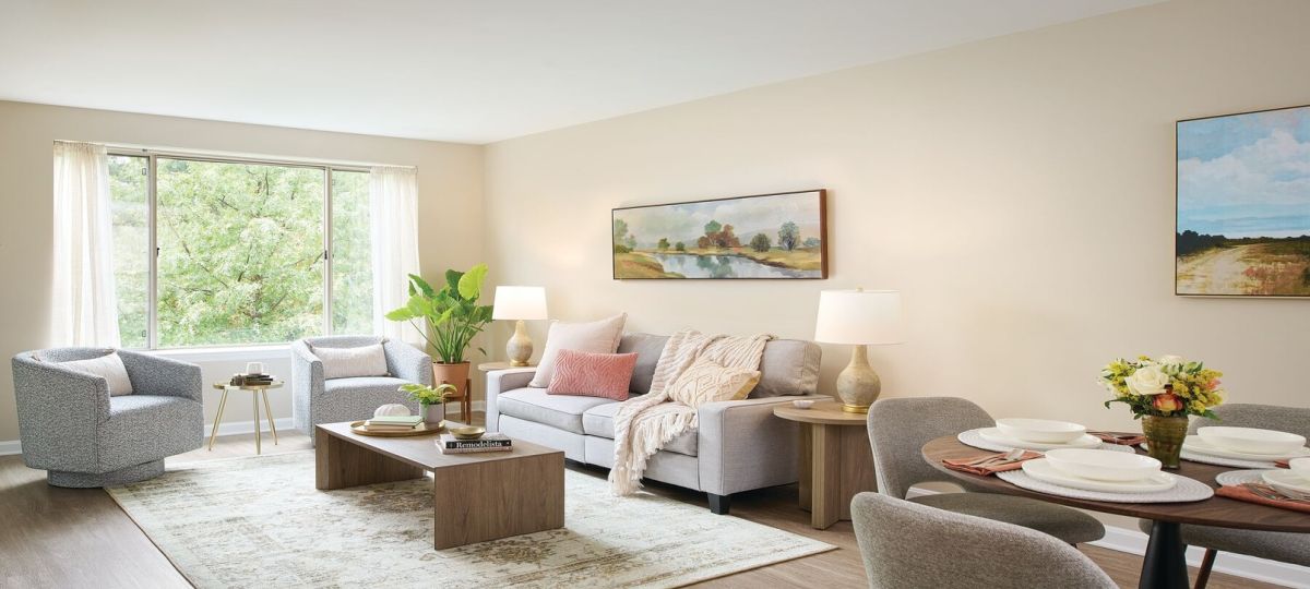 Wide angle shot of a spacious, open living room and dining area in an Erickson apartment.