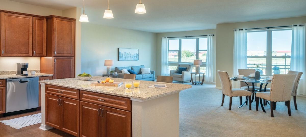 Wide angle shot of a spacious, open living room and dining area in an Erickson apartment.