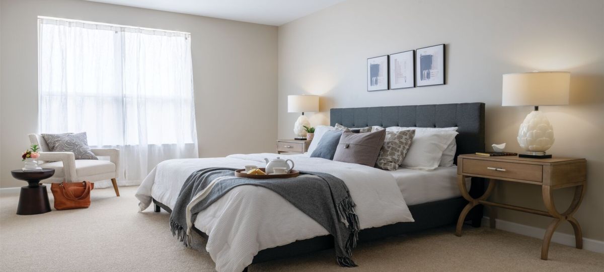 Cozy bedroom in an Erickson Senior Living community apartment with modern furnishings.