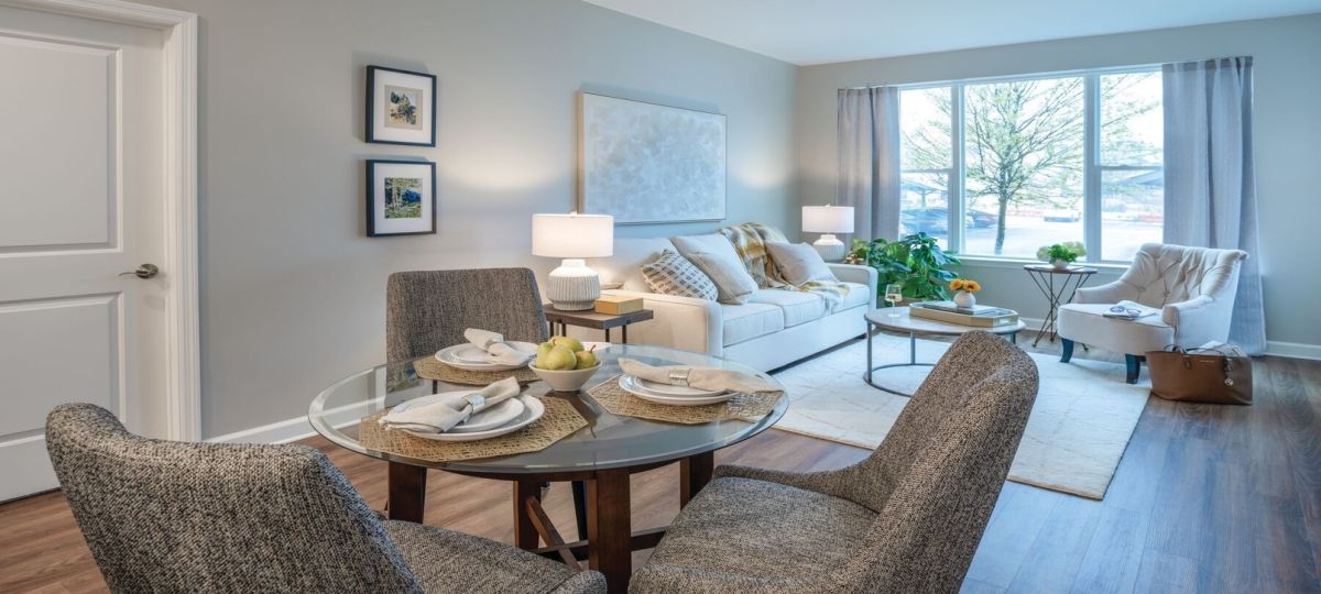 Wide angle shot of a spacious, open living room and dining area in an Erickson apartment.
