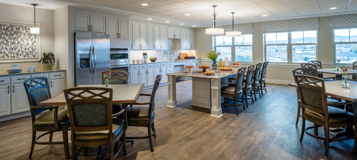 Wide-angle shot of a bright and spacious dining area in an Erickson community building, featuring modern furnishings and an inviting atmosphere.